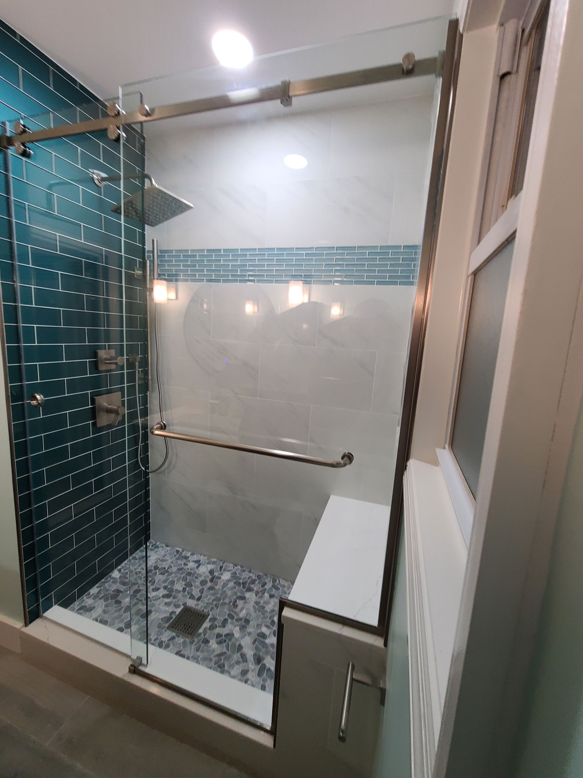 A bathroom with a sliding glass shower door