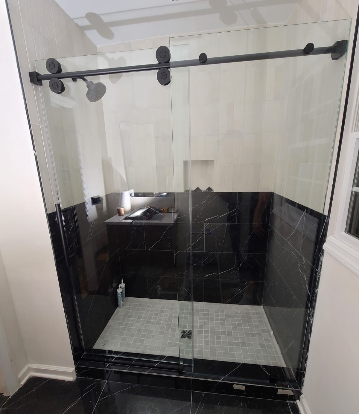 A bathroom with a sliding glass shower door