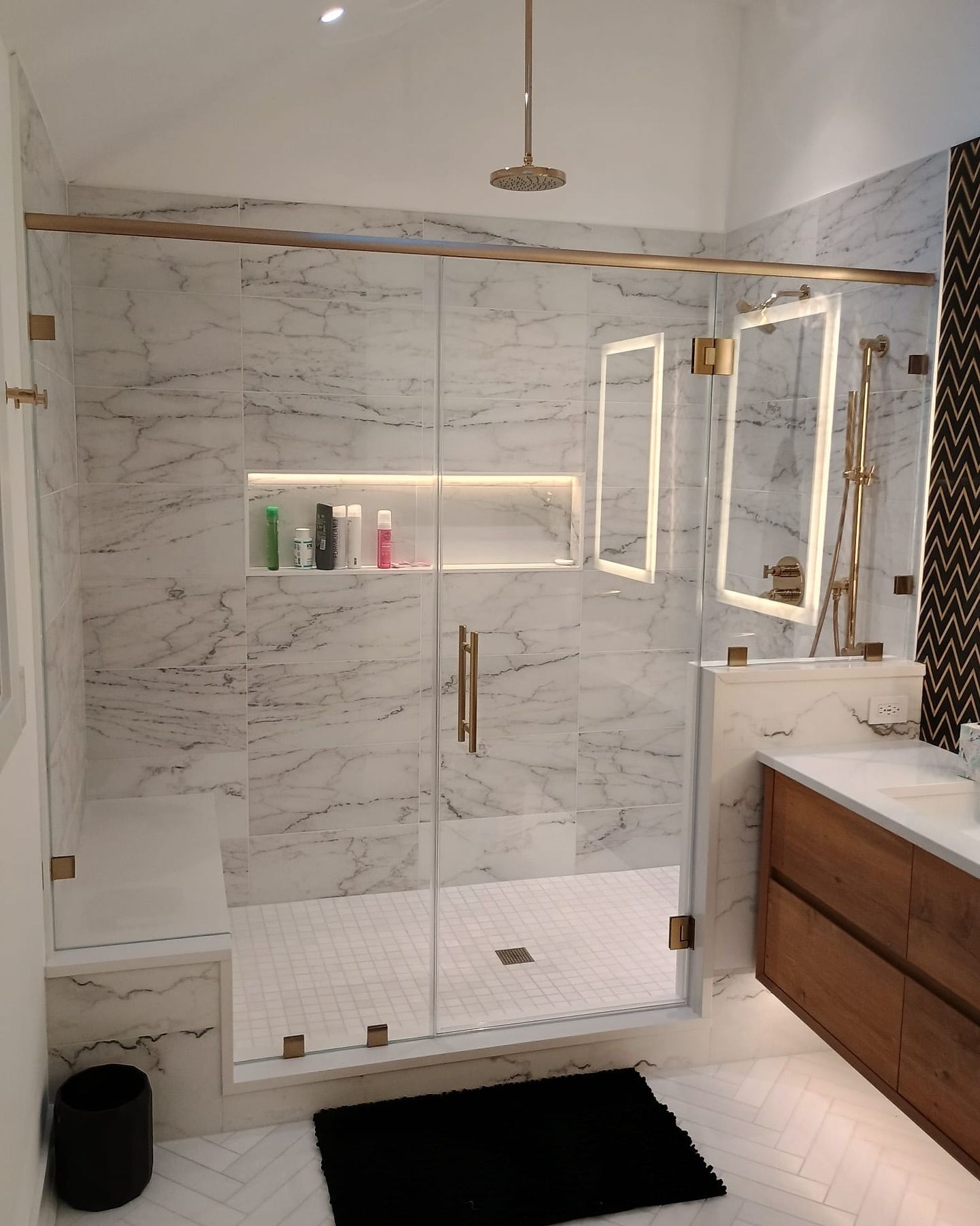 A bathroom with a walk in shower and a sink