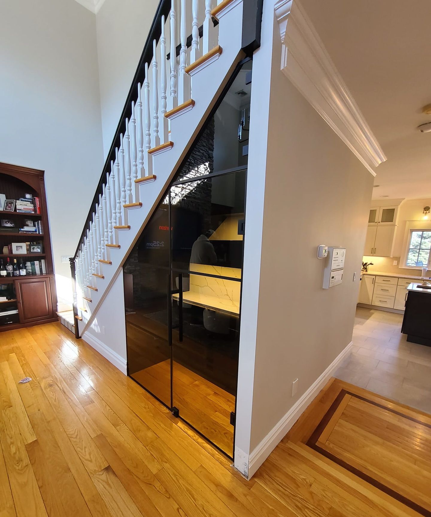 A staircase in a house with a glass door underneath it.
