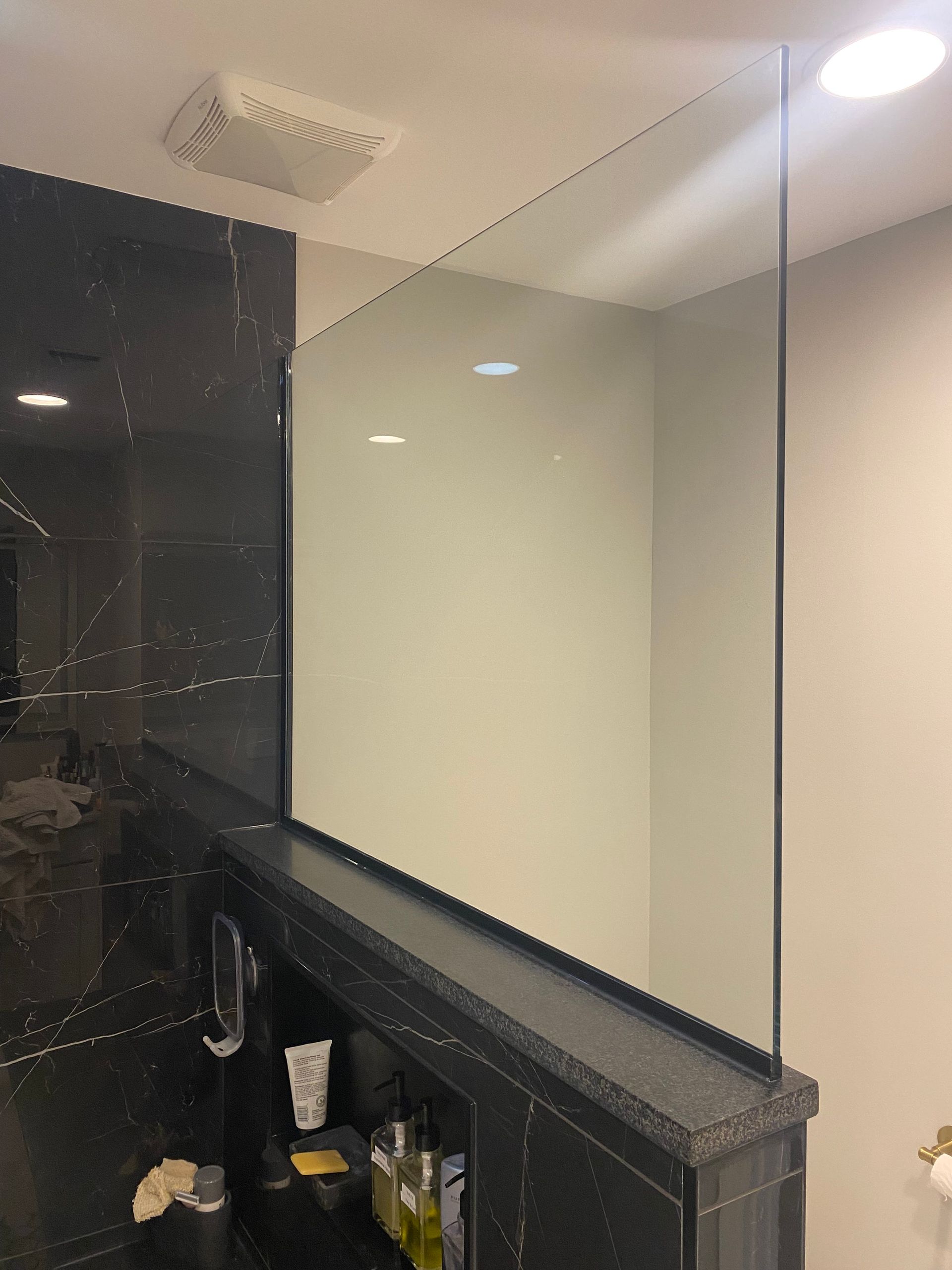 A bathroom with a large mirror on the wall.