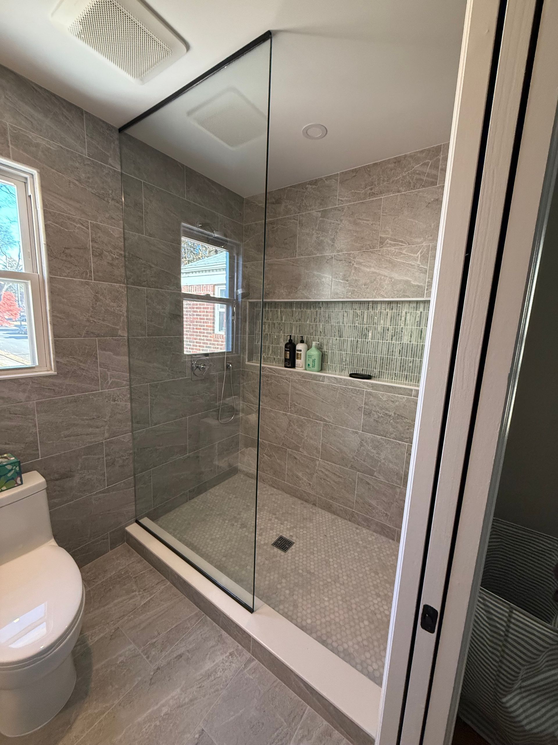 A bathroom with a toilet and a walk in shower.