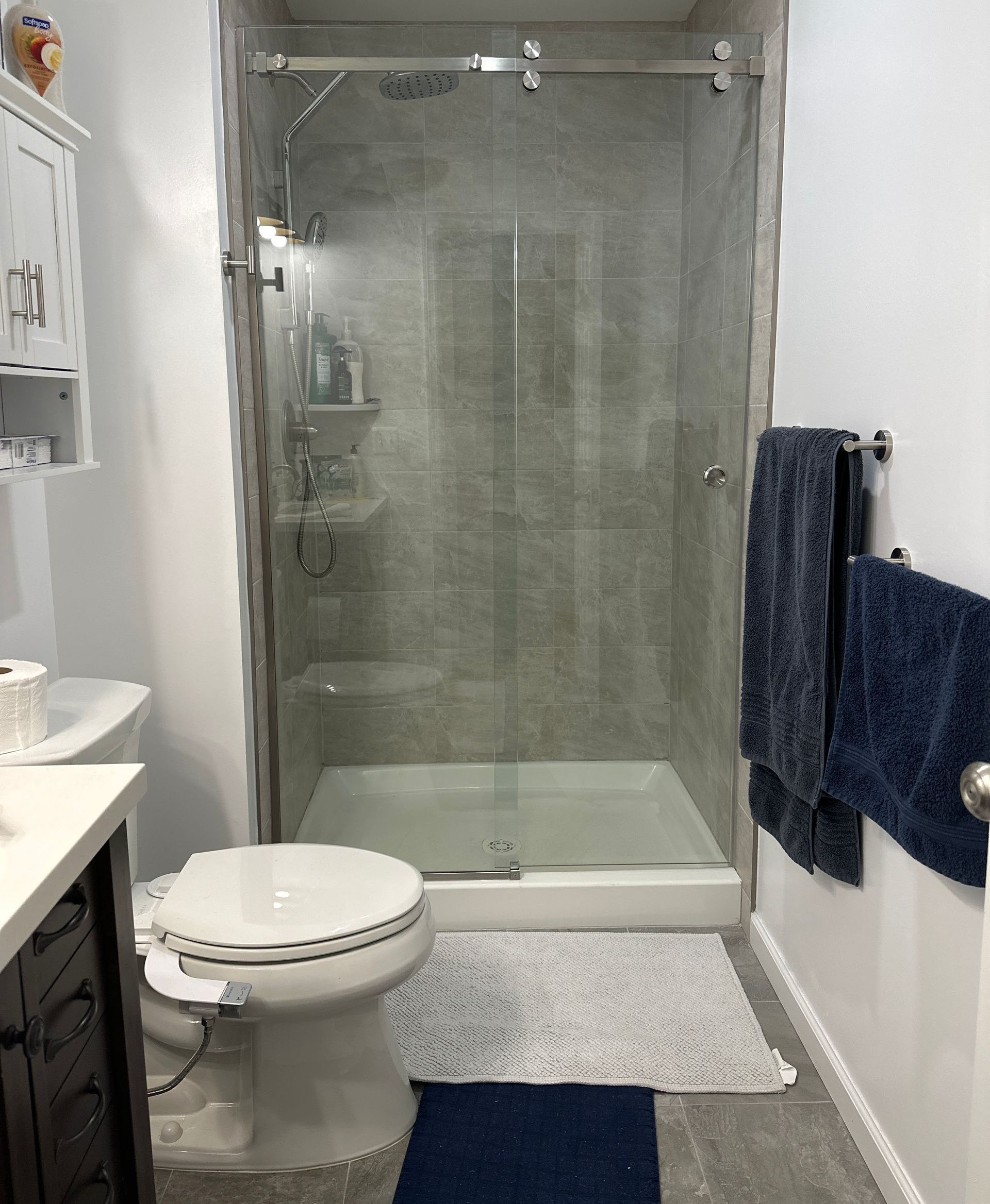 A bathroom with a toilet , sink , and shower.