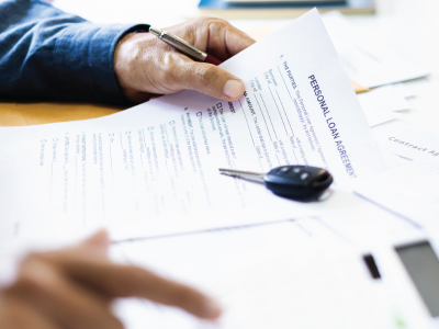 Hands holding pen and document labeled 