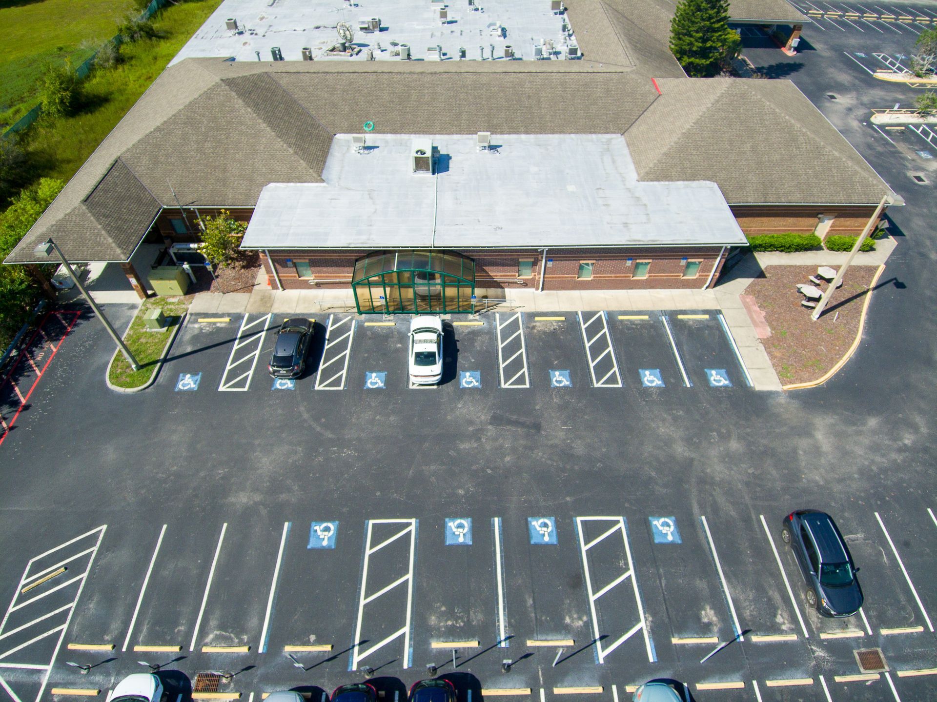 Aerial view of building with accessible parking spaces and vehicles.