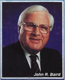 A man in a suit and tie is named john r. baird
