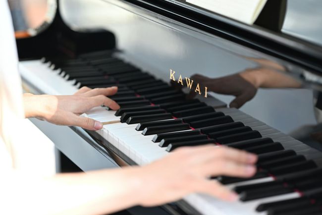 A person playing a kawai piano.