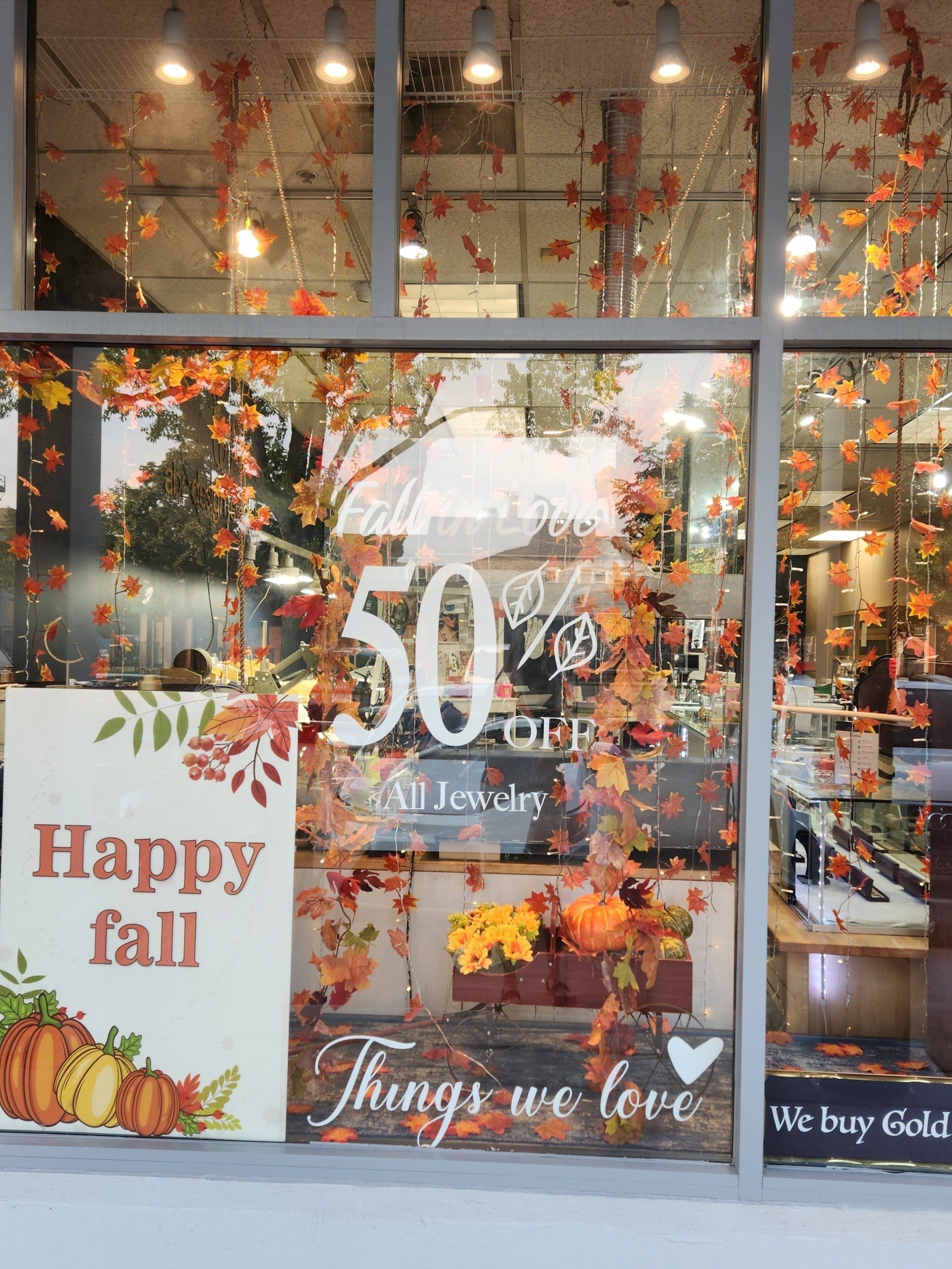 A store window with a sign that says happy fall