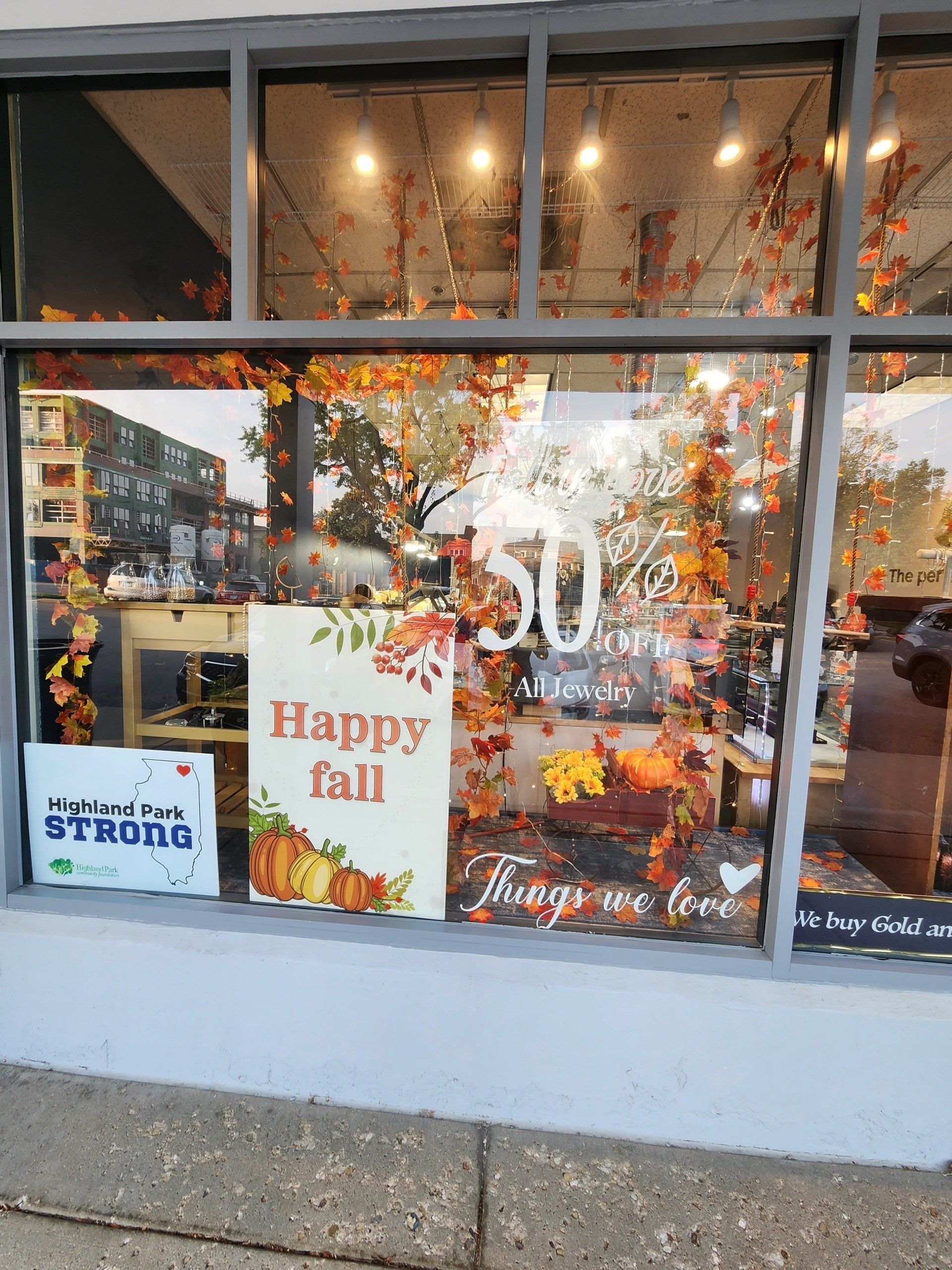 A store window with a sign that says happy fall