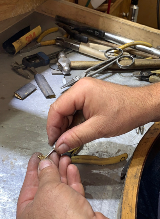 A close up of a person 's hands working on a ring