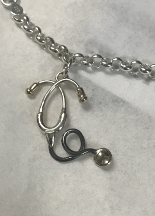 A silver necklace with a stethoscope charm on it