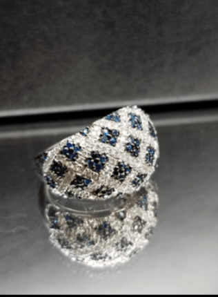 A silver ring with blue and white stones on it
