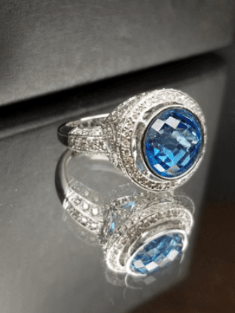 A silver ring with a blue stone in the center