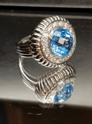 A silver ring with a blue stone and diamonds