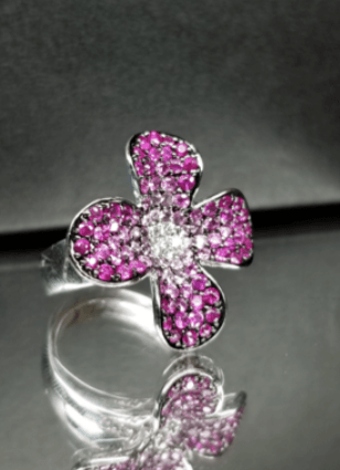 A silver ring with pink stones in the shape of a flower