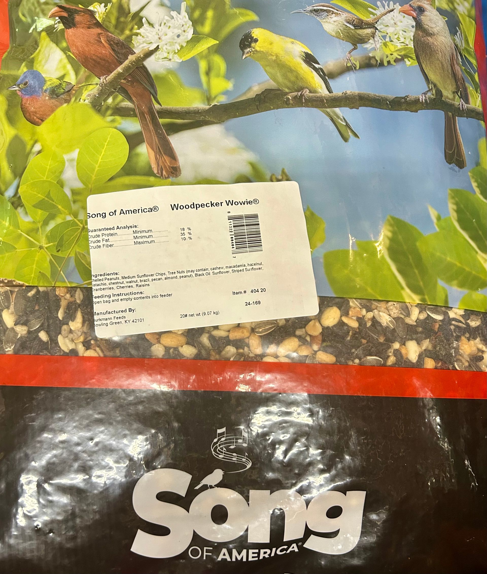 Bag of Song Of America birdseed with a label on the front, featuring a colorful image of various birds perched on tree branches.