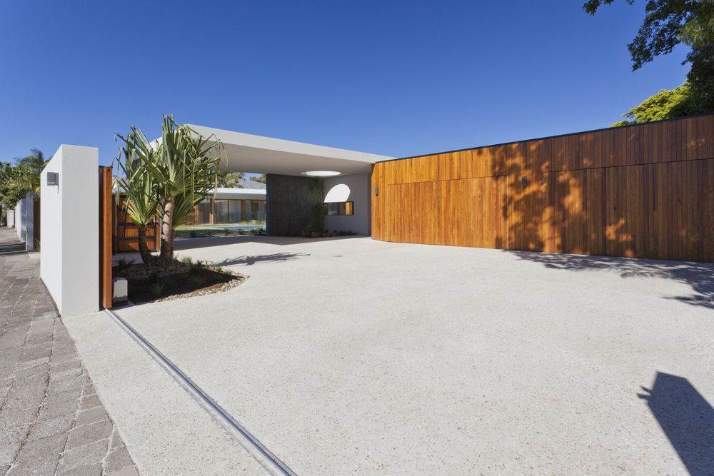 A Modern House With A Large Driveway And A Wooden Fence — Settle Petal Mobile Conveyancing In Wingham, NSW