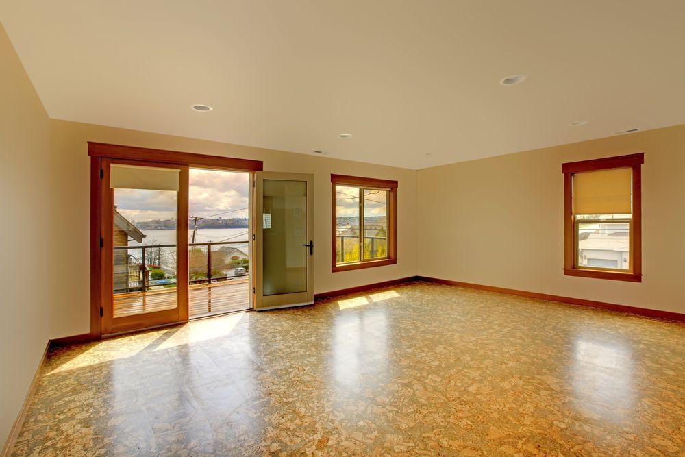 An Empty Living Room With A Cork Floor And Sliding Glass Doors — Settle Petal Mobile Conveyancing In Wingham, NSW