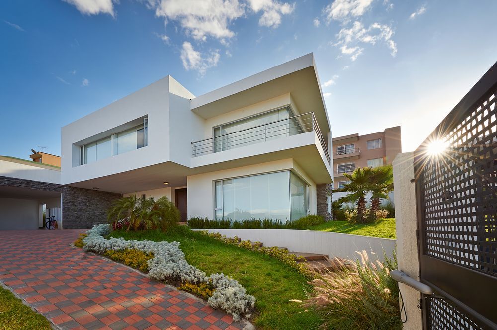 A Large White House With A Brick Driveway And A Fence In Front Of It — Settle Petal Mobile Conveyancing In Tuncurry, NSW