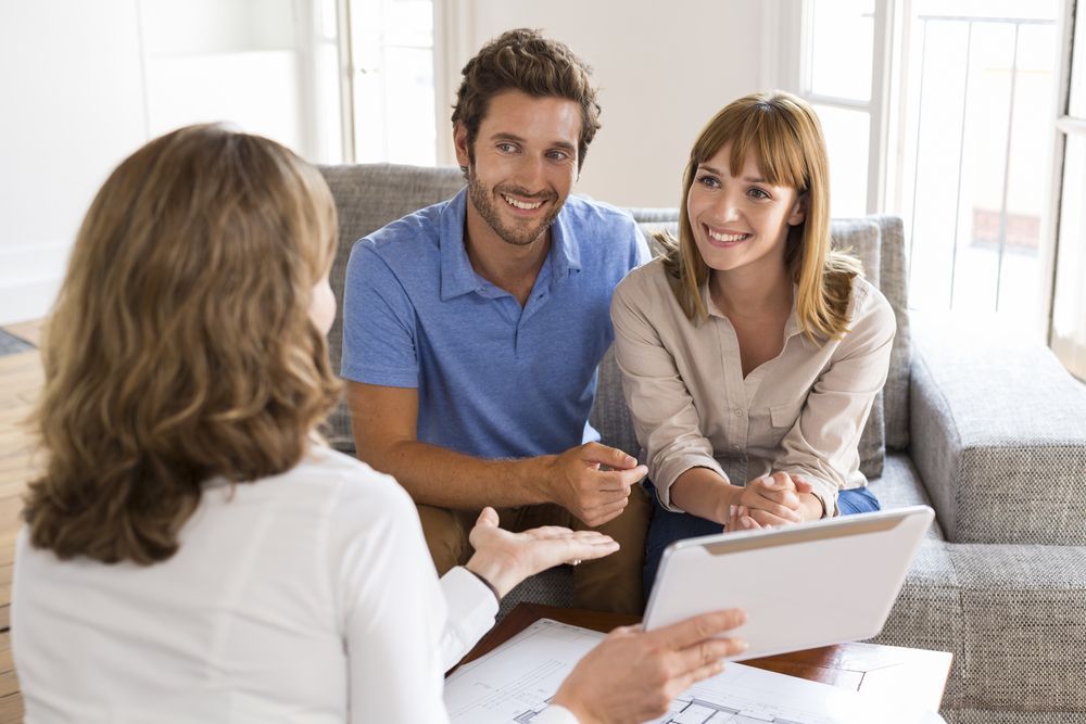 A Man And A Woman Are Sitting On A Couch Talking To A Woman — Settle Petal Mobile Conveyancing In Wallabi Point, NSW