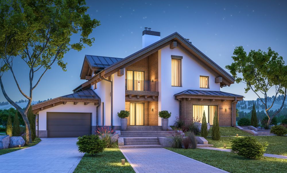 A Large White House With A Garage And A Driveway Is Lit Up At Night — Settle Petal Mobile Conveyancing In Taree, NSW