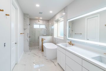 spacious elegant white bathroom with bathtub and shower