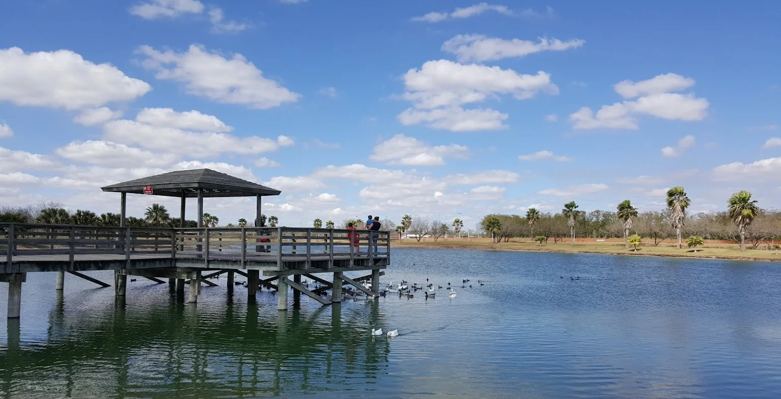 a couple standing on a pier overlooking a lake .