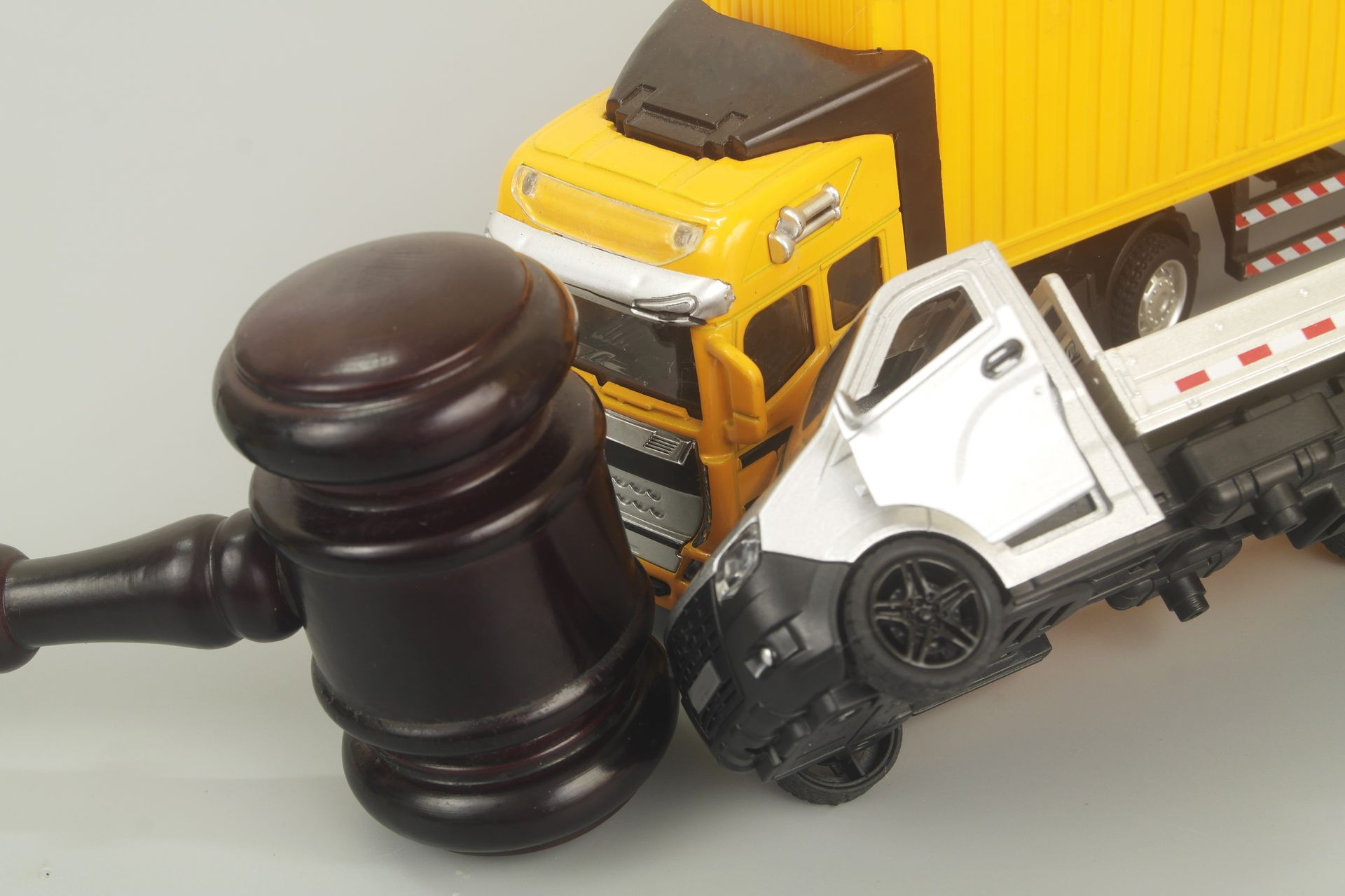 Truck accident lawyer concept with gavel and toy truck collision symbolizing legal case claims.