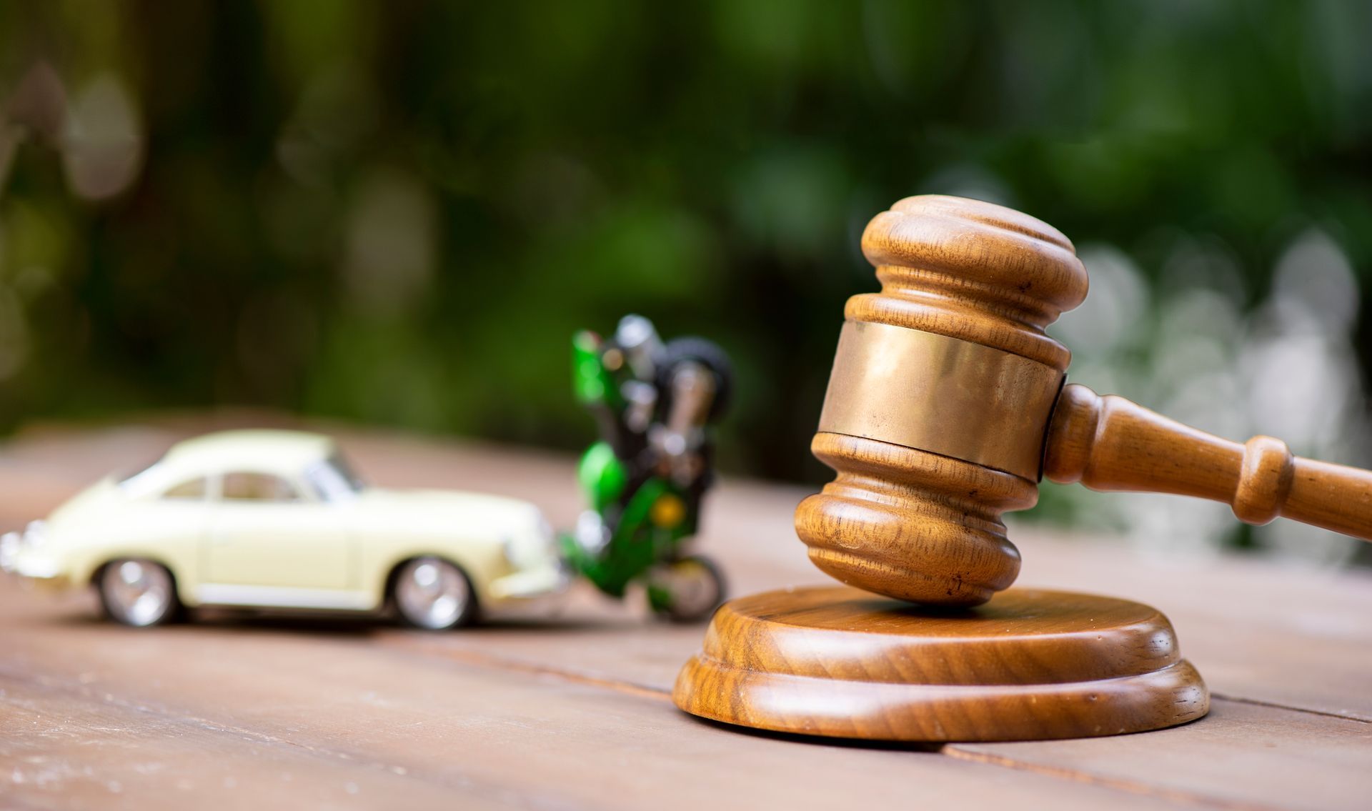 A judge's hammer with a car and motorbike collision in the background. A judge's hammer with a car and motorbike collision in the background.
