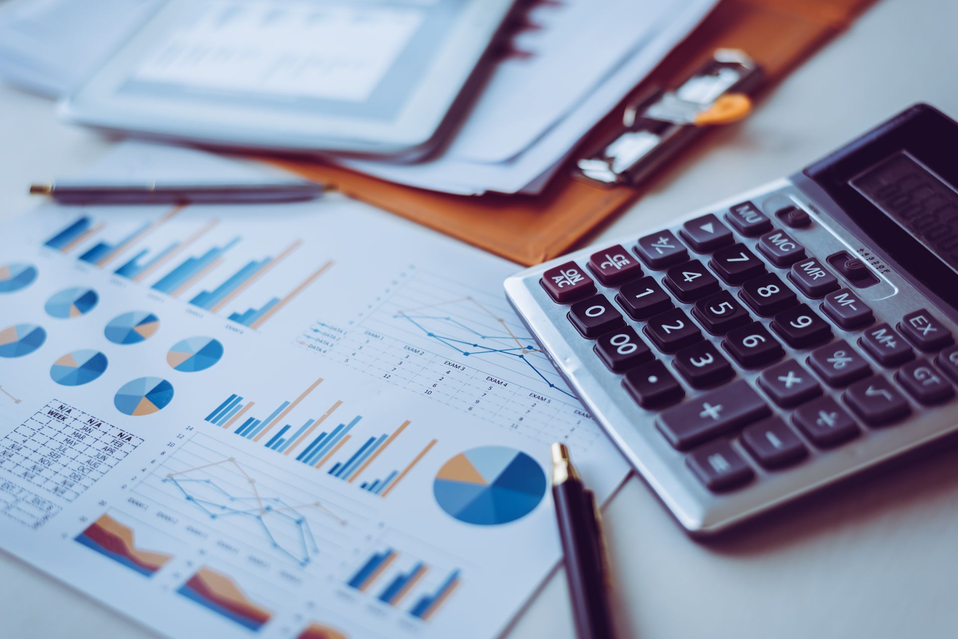 Financial reports with charts and a calculator on a desk