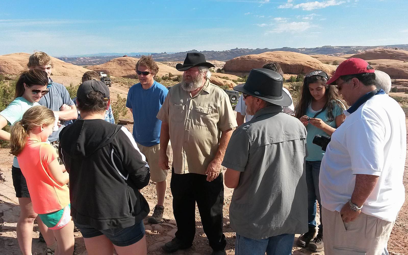 a group of people are standing in a circle talking to each other .