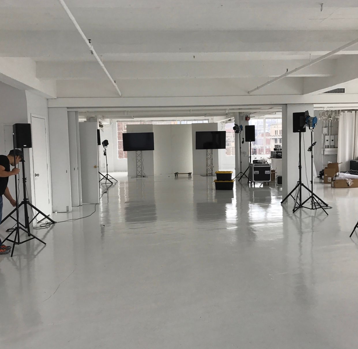 A man is taking a picture in a large white room.