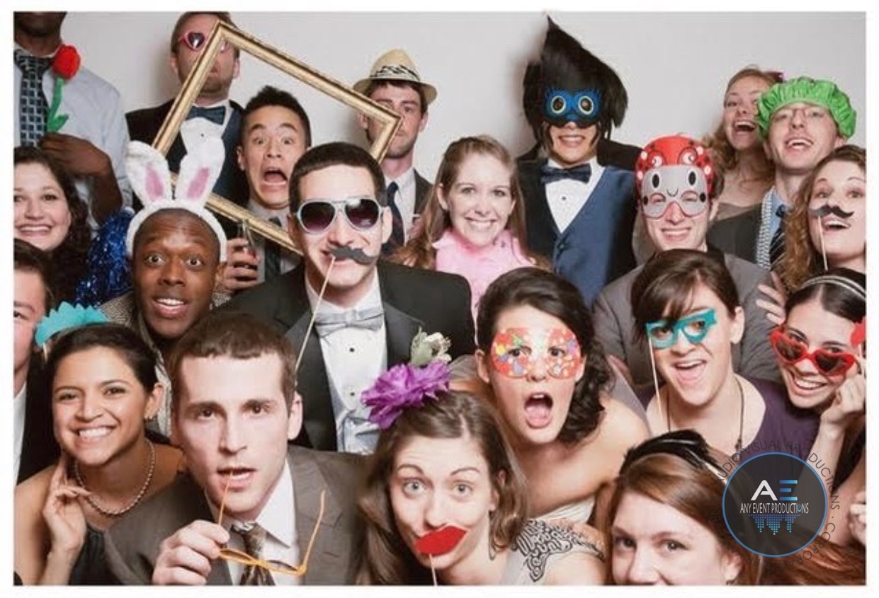 Group of people posing with photo booth props, showing excited expressions.