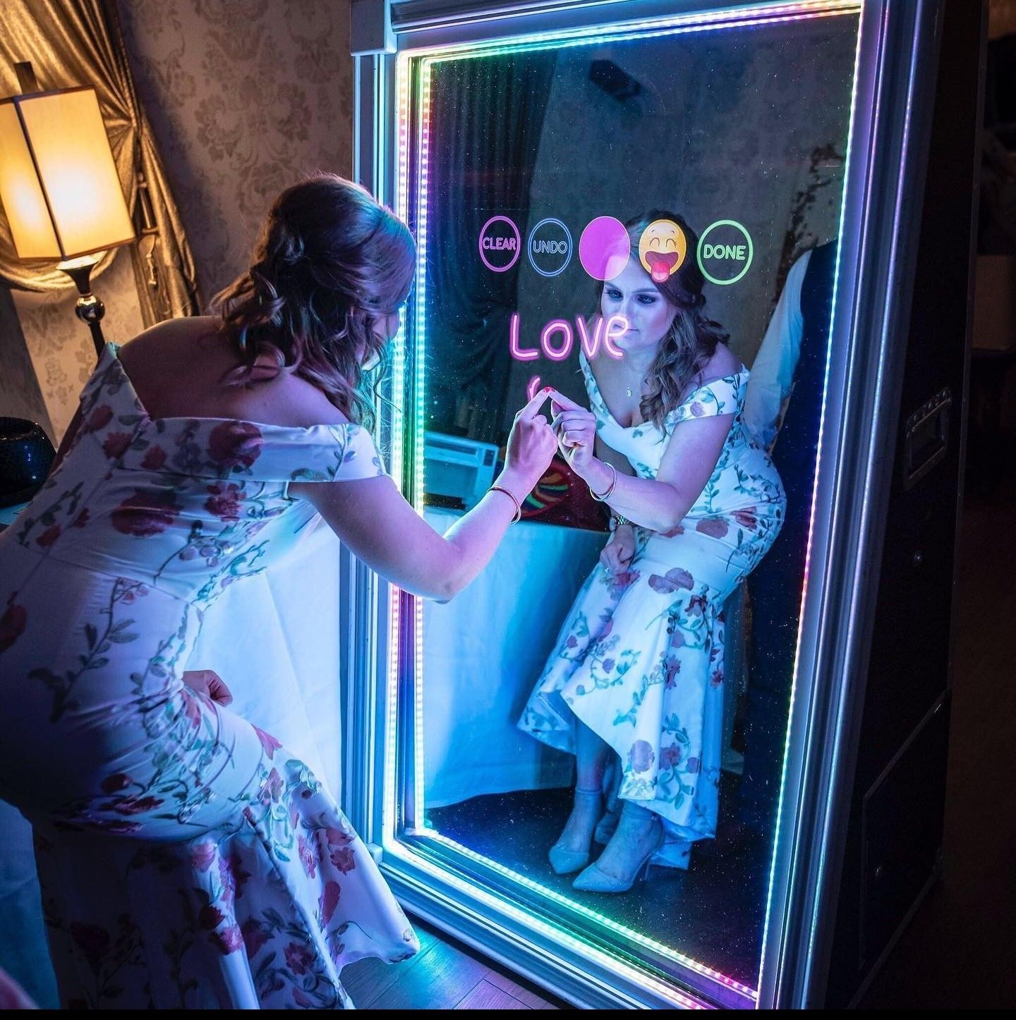 A woman is taking a picture of herself in a mirror that says love.