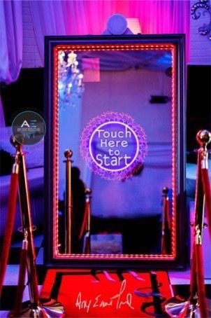A large mirror with a sign that says touch here to start.