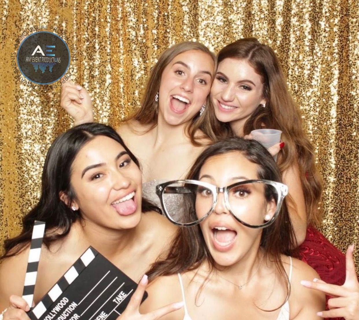 A group of women are posing for a picture in front of a gold curtain.