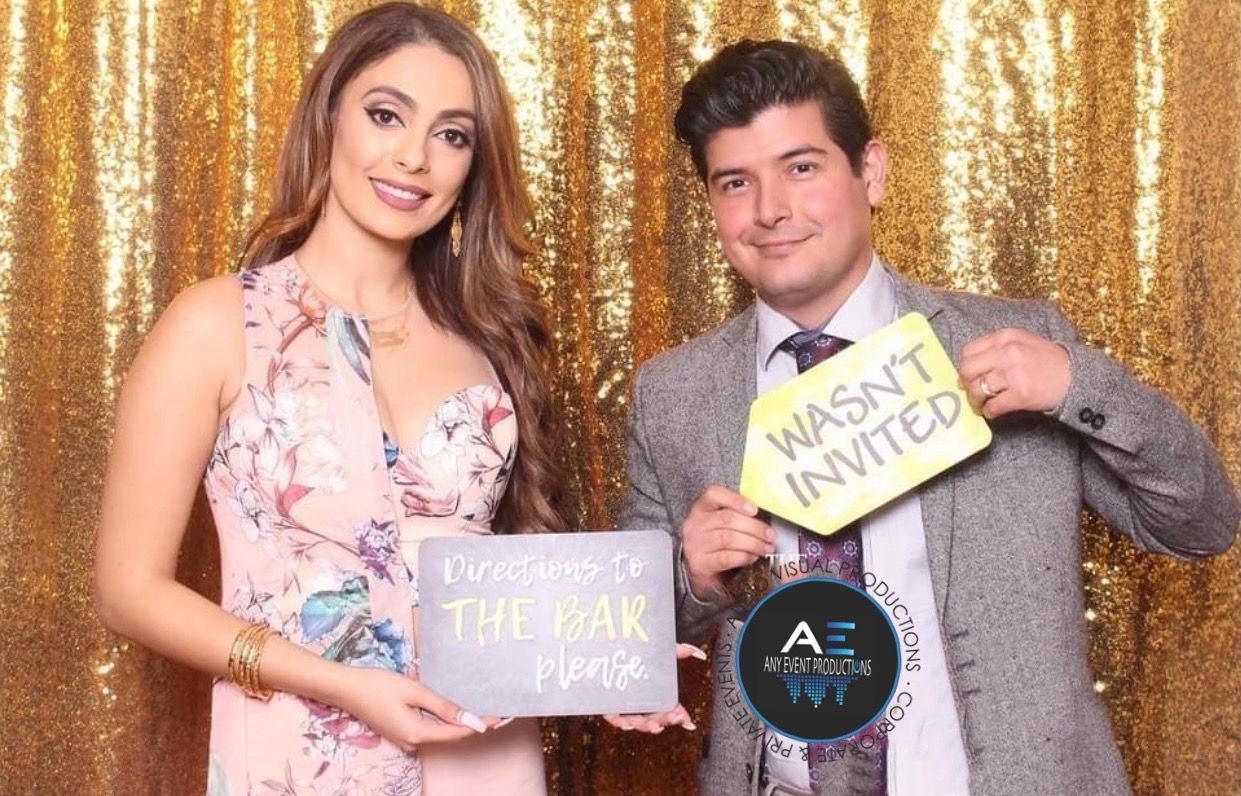 A man and a woman are posing for a picture in a photo booth.