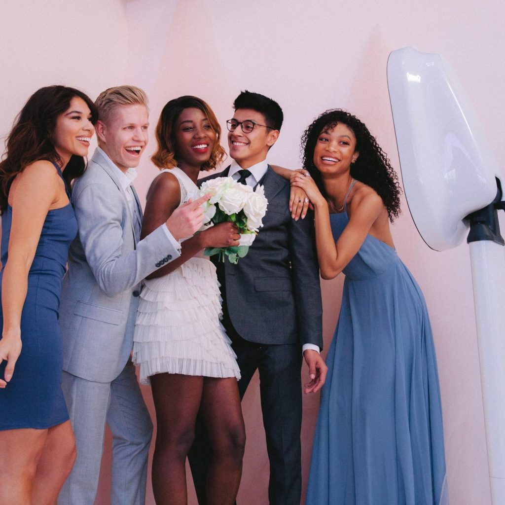 A group of people posing for a picture in front of a photo booth.