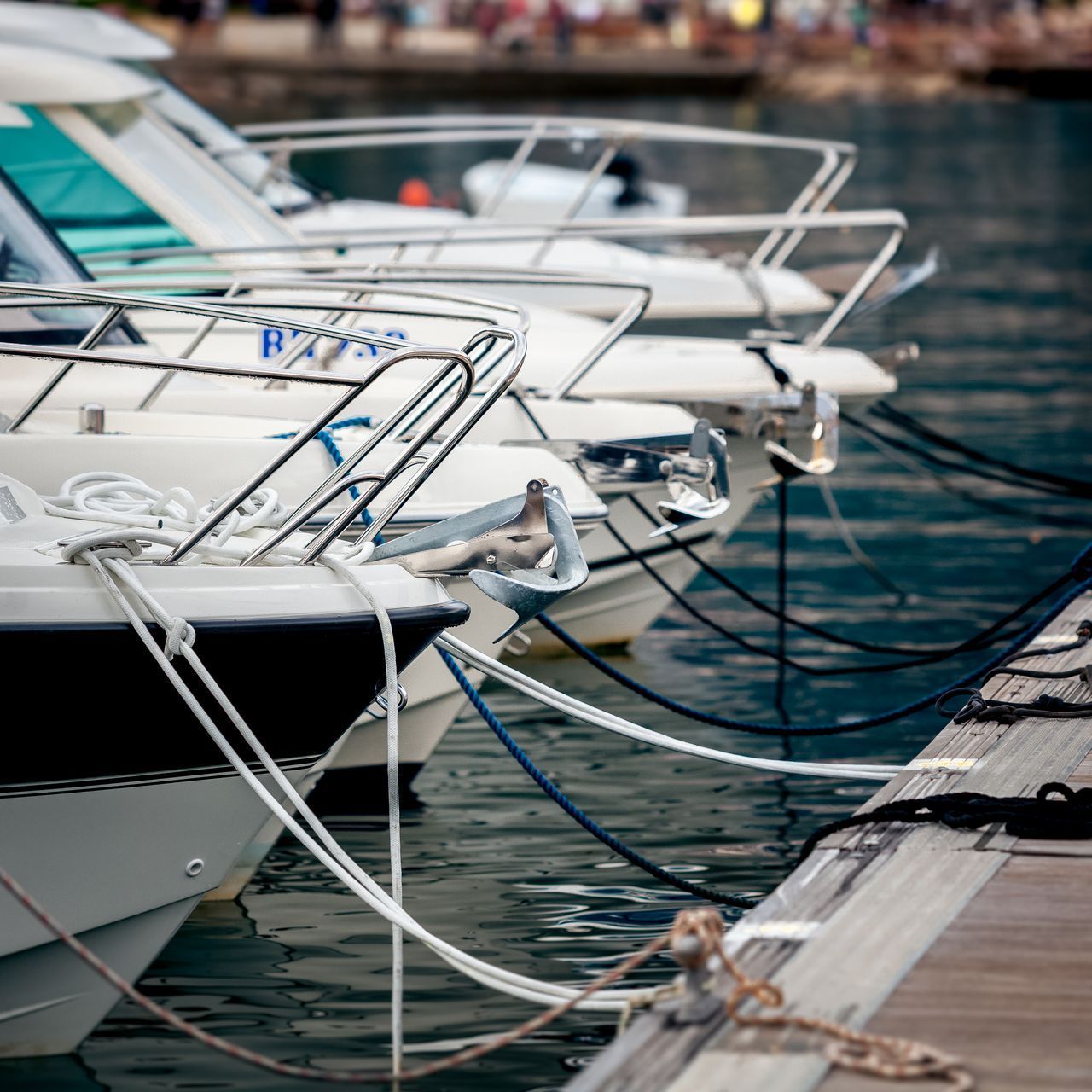a row of boats are tied to a dock with anchors and ropes
