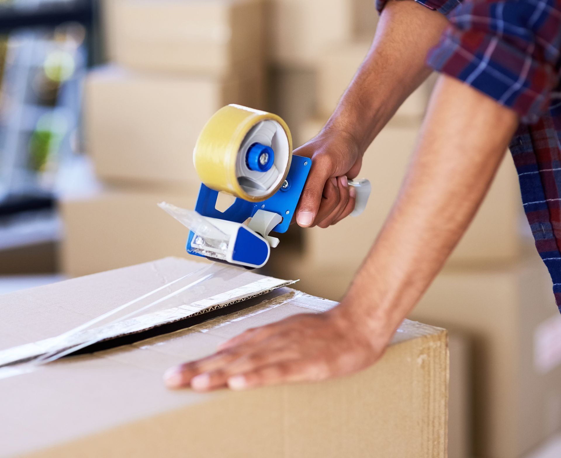 Man sealing a box with tape