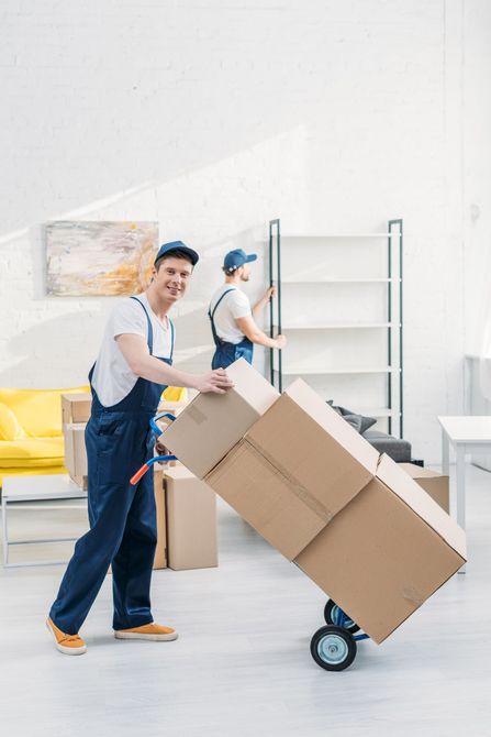a man is pushing a cart full of cardboard boxes