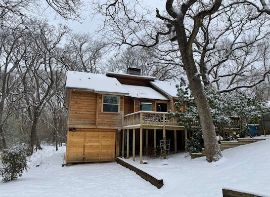 A house with a garage and a deck in the snow