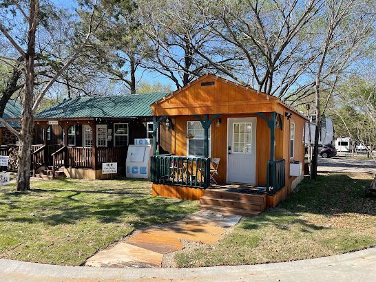 A small orange house with a green roof and a porch.