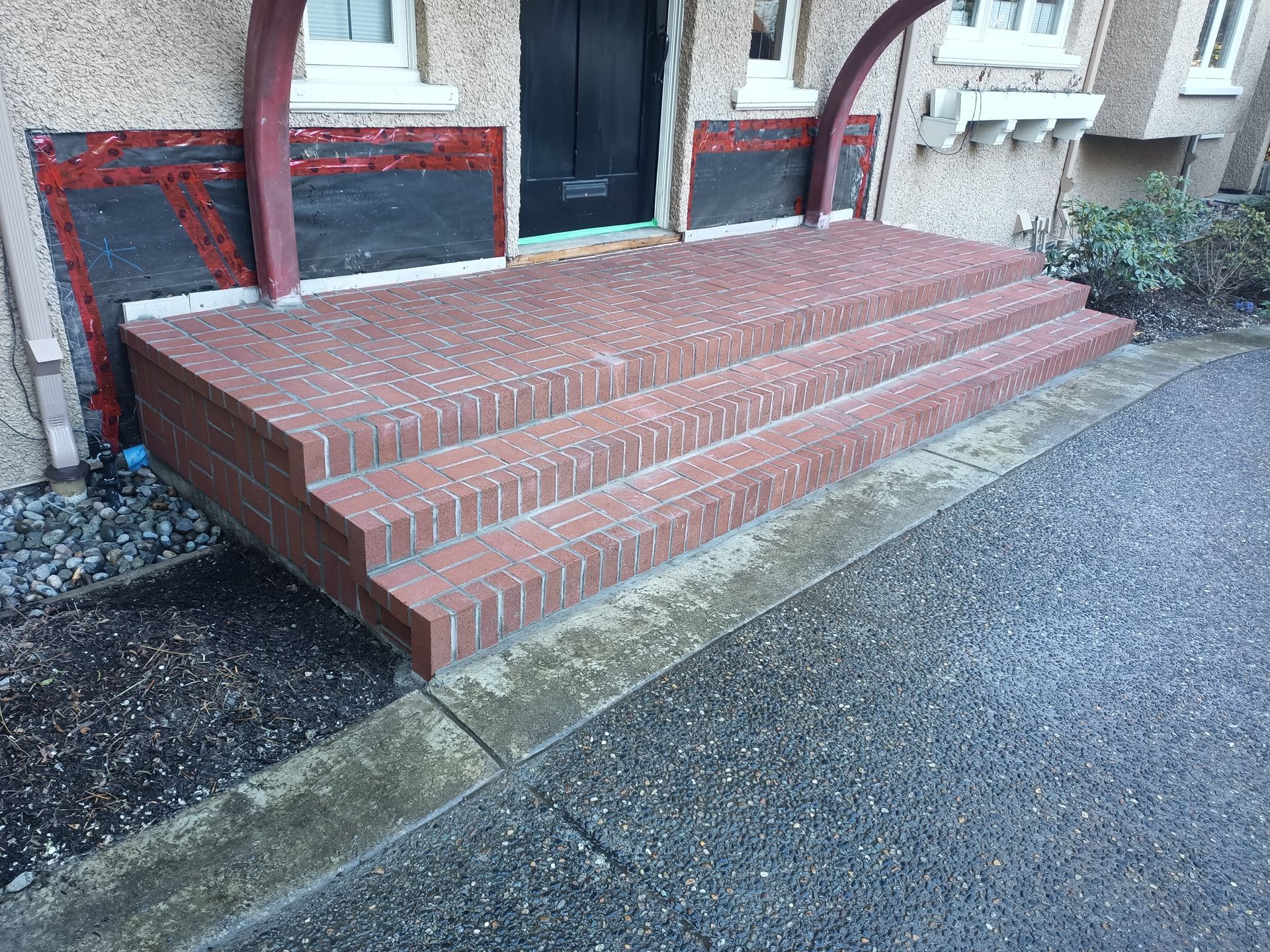 Brick front steps with a low accessible ramp beside a building entrance