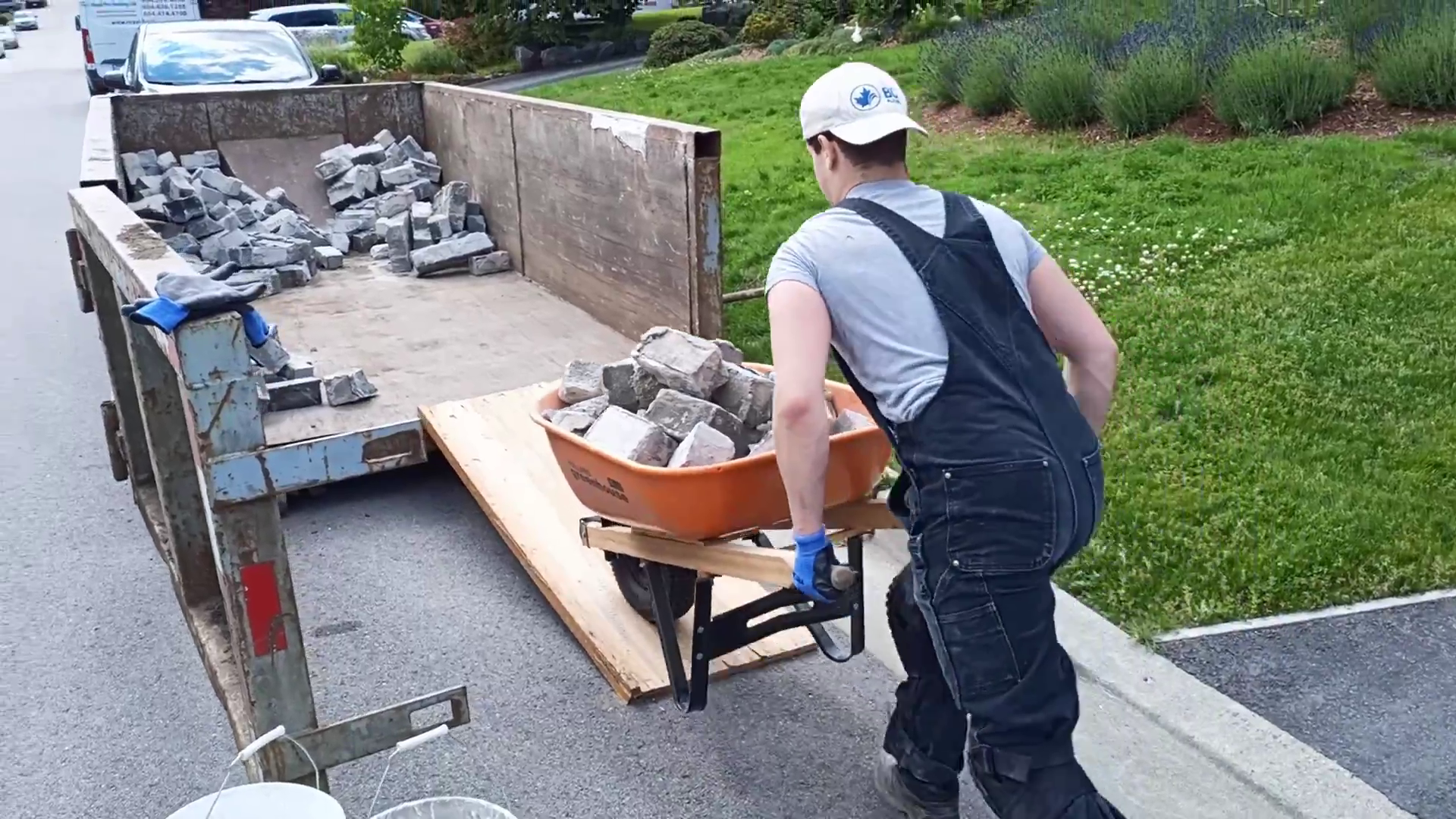 Bricked Masonry worker using wheelbarrow to bring rubble into trailer