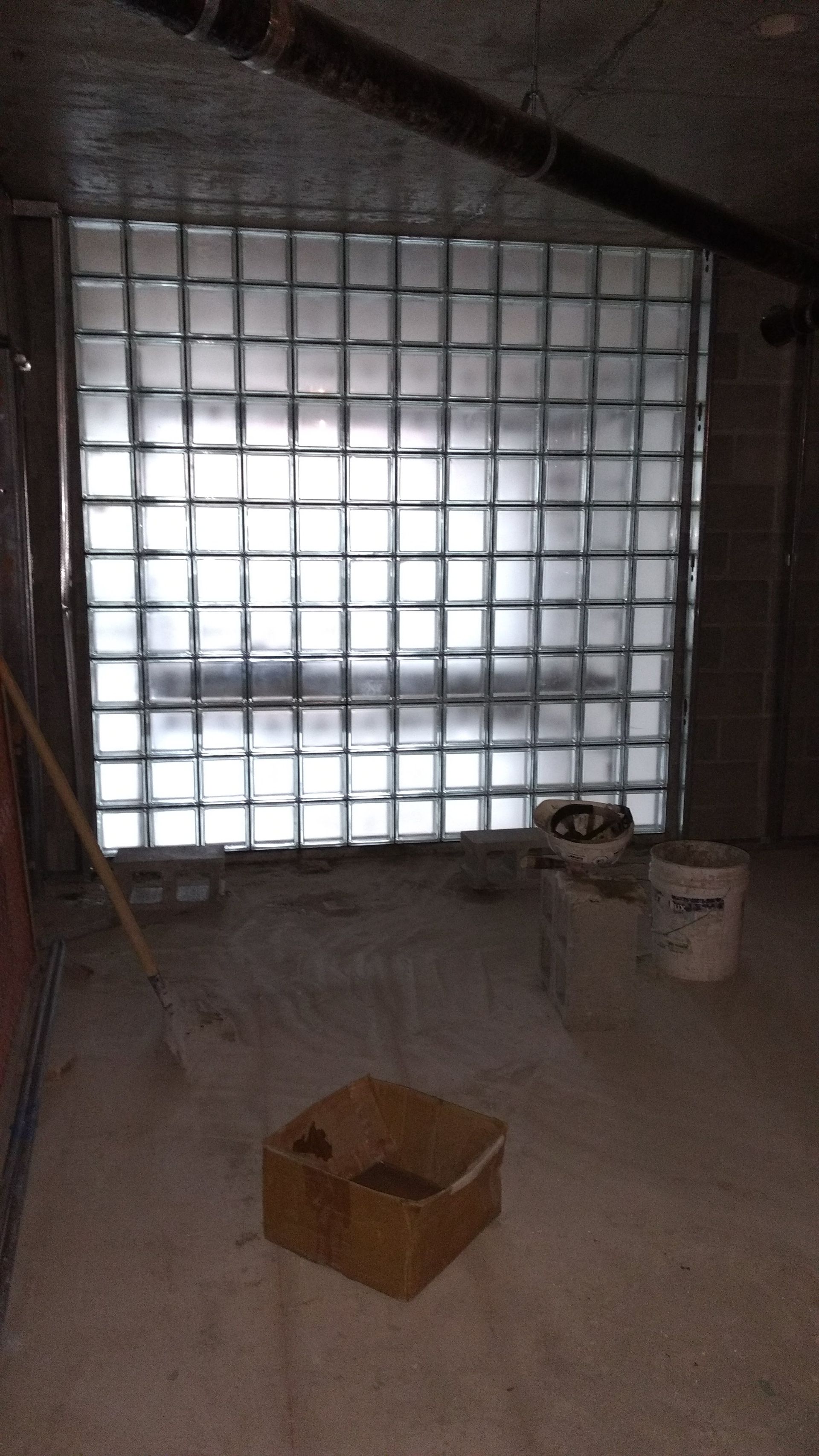 A glass block window freshly installed with the work environment still surrounding it.