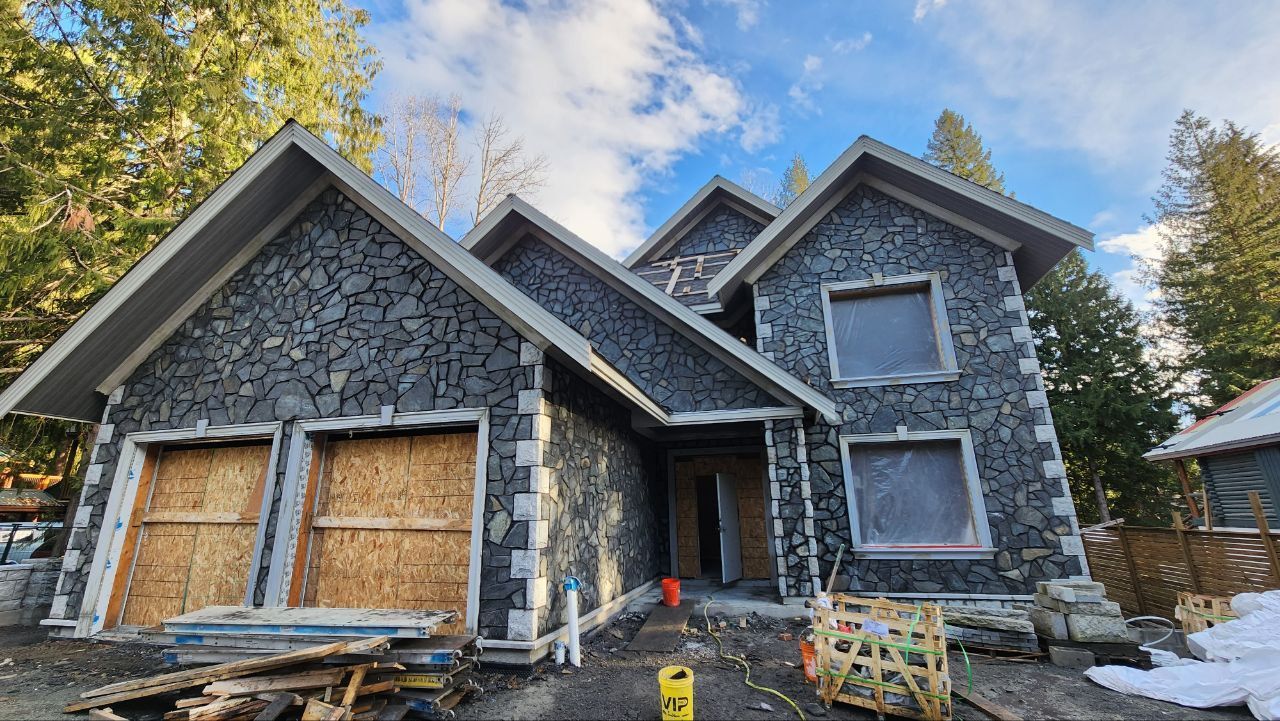 Natural stone siding installed on the exterior of a new house by Bricked Masonry in Vancouver, Canada.