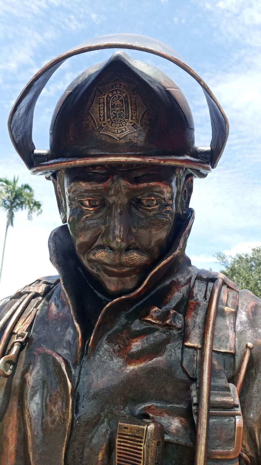 A bronze statue of a fireman wearing a helmet.