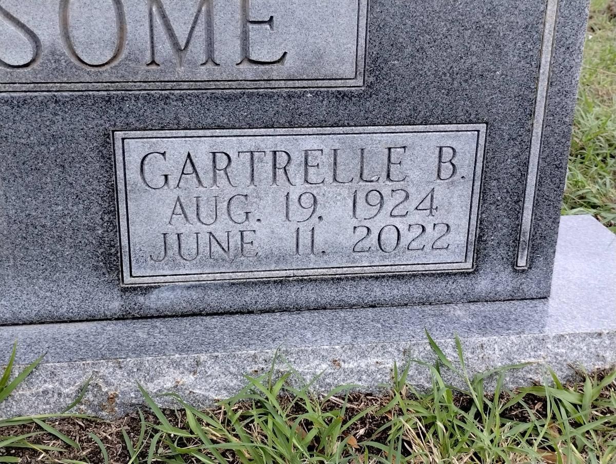 A gravestone with a plaque on it that says gartrelle b. aug 19 1924 june 11 2022.