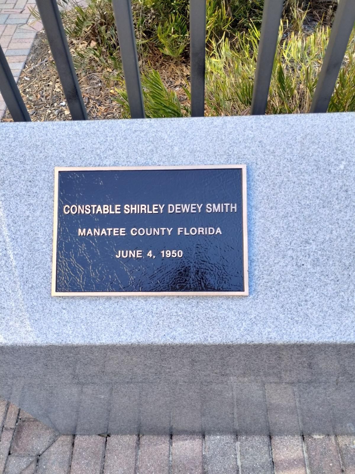 A plaque on a stone wall commemorates a man named dewey smith